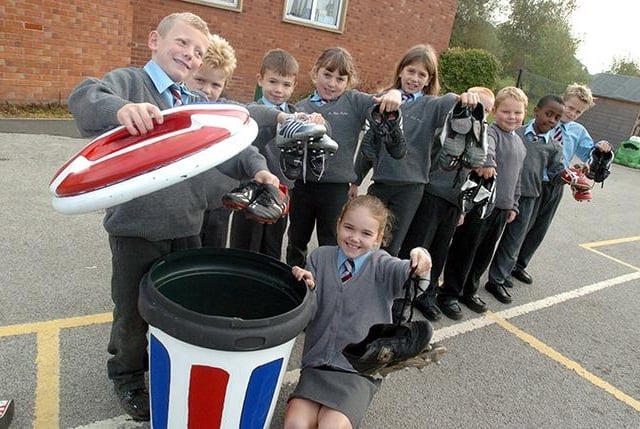 Children at St John Fisher School, Hackenthorpe, with football boots for shipment to India, and the bin to collect them in. Pictured foreground are Mitchell Ward and Anna Womack, on October 15, 2004