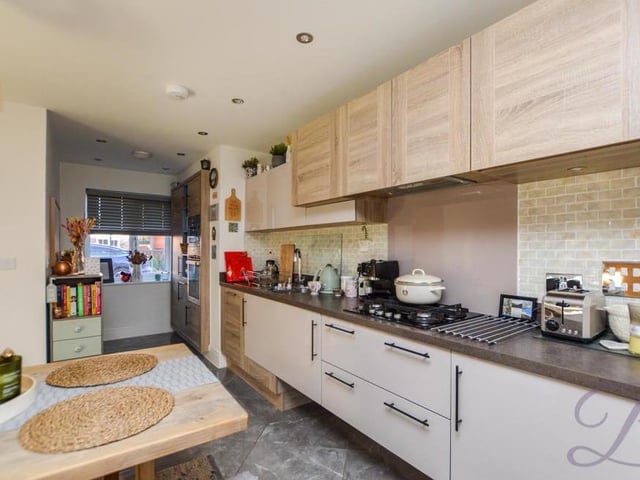 Another view of the quality kitchen, which benefits from a range of integrated appliances, including an electric oven and microwave. It is finished beautifully with chrome sockets, while the floor is tiled throughout.