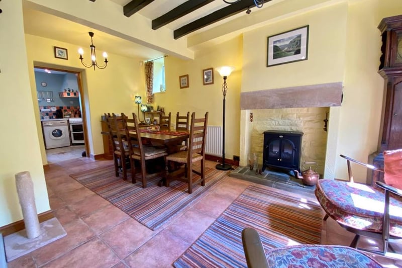 In the dining room, there is a terracotta-style ceramic tiled floor, exposed ceiling timbers and a stone built fireplace with tiled hearth housing an electric, log-effect fire.
