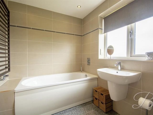 Above the bath is a heated towel rail.