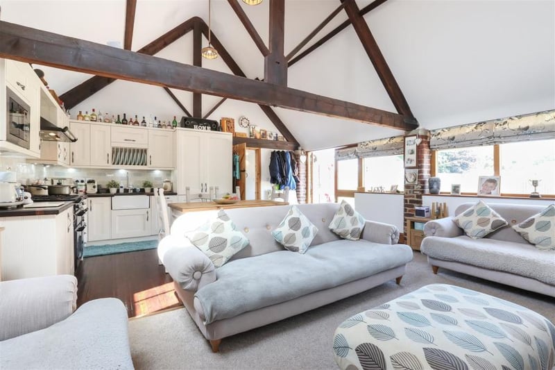 The open-plan living space boasts exposed oak beams.