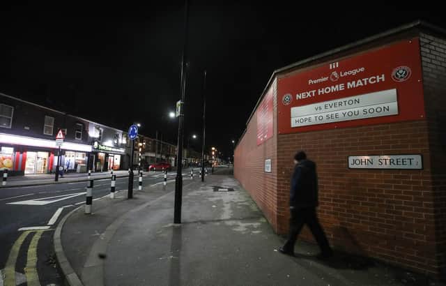 A man walks down an empty street before the English Premier League football match between Sheffield United and Everton at Bramall Lane (Photo by NICK POTTS/POOL/AFP via Getty Images)