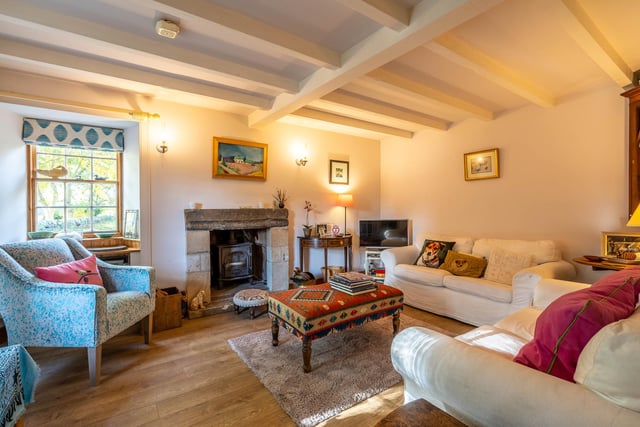 The living room boasts a wood-burning stove, set in a recessed original fireplace
