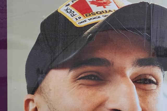 The slogan on the young man's baseball cap reads 'F**K ALL BUT THE FLAG'.