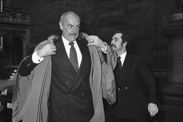 Scottish actor Sean Connery gets gowned to receive his honorary degree from Heriot-Watt university in November 1981. Man on right not identified.