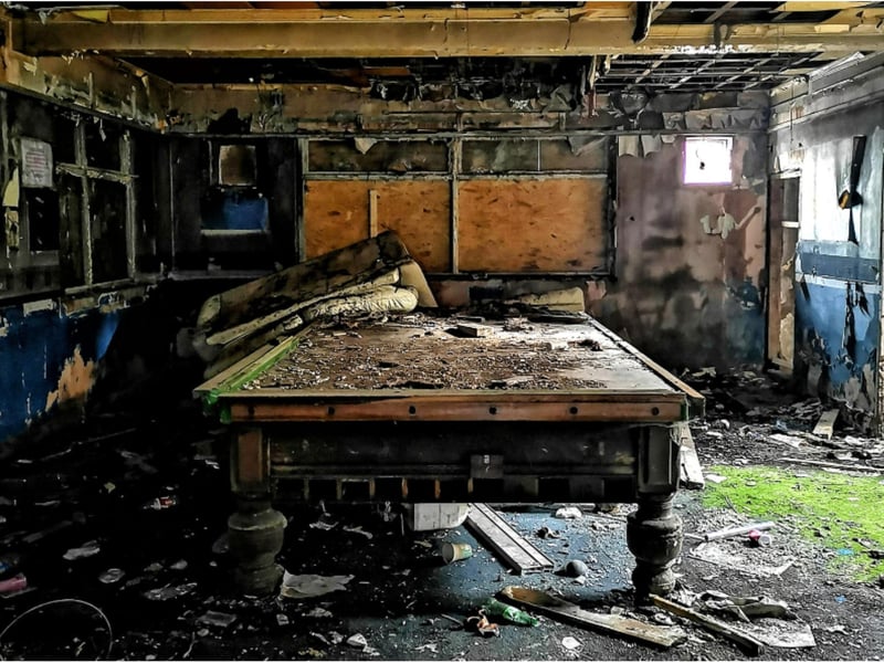 A full size snooker table remains among the debris.