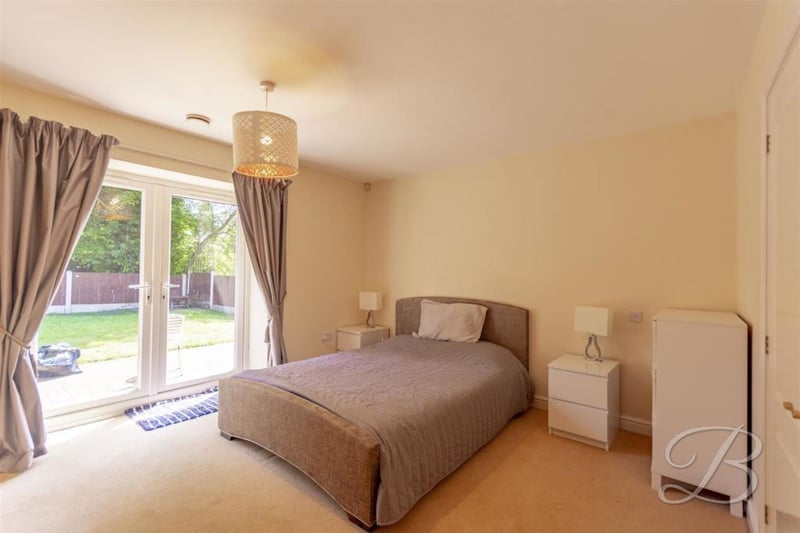 One of the five bedrooms at the property. It has fitted wardrobes, access to an en-suite and even its own patio doors.