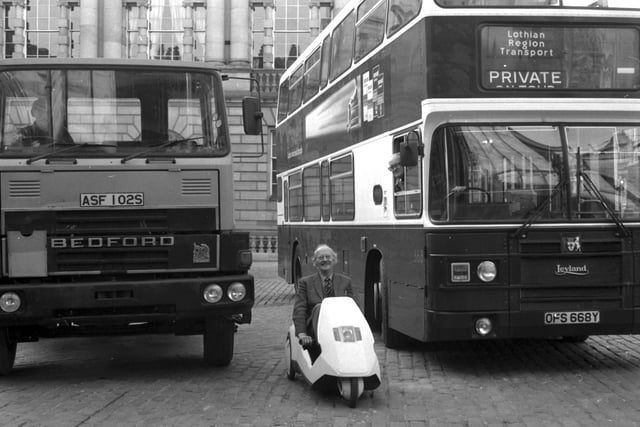 Edinburgh councillor Hugh Fraser parks his Sinclair C5 car between a bus and lorry in Parliament Square in January 1985.