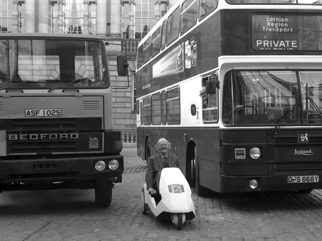 Edinburgh councillor Hugh Fraser parks his Sinclair C5 car between a bus and lorry in Parliament Square in January 1985.