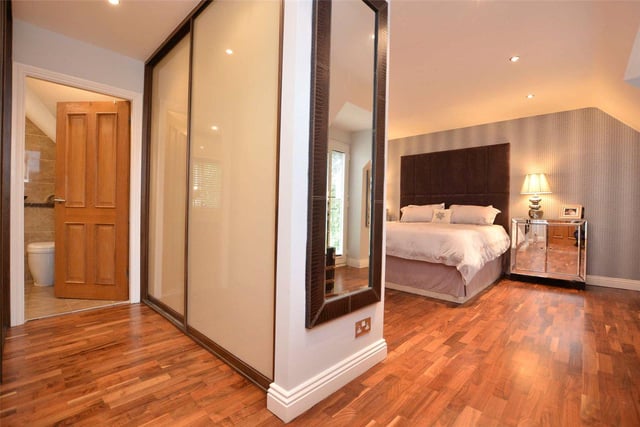 There are five bedrooms in total including this spacious master suite, which features walnut wood flooring, a dressing room area and en-suite bathroom, with a walk-in shower cubicle.