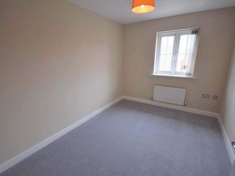 Bedroom 2 - A double bedroom having modern grey carpet, radiator, stainless steel double socket point and UPVC double glazed window with fitted blind.