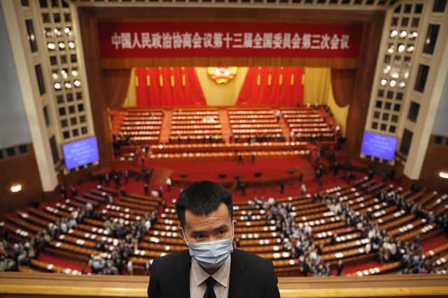 A security person prepares to clear the stands as delegates leave after the closing session of the Chinese People's Political Consultative Conference (CPPCC) at the Great Hall of the People in Beijing on Wednesday, May 27, 2020. (AP Photo/Andy Wong)