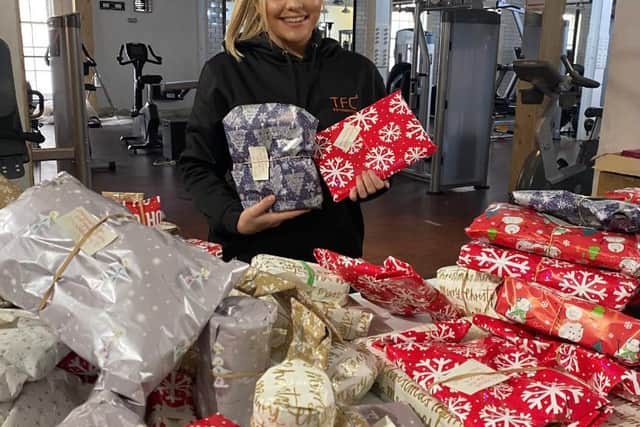 Holly Beeby at TFC gym in Sheffield with gifts she has collected to help struggling families have a better Christmas
