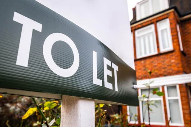 Estate agency 'To Let' sign board on street of red brick houses