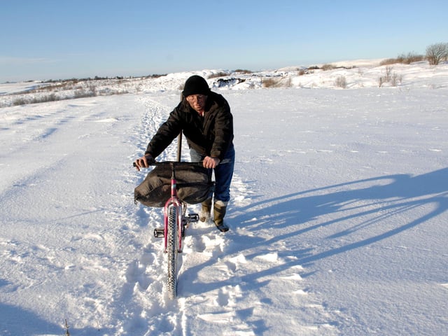 The snow steppe at Plains in Lanarkshire, winter 2010. Local man William Gault (55yrs old) travelled just under 2 miles in heavy snow, pushing his bike to and from an open cast mine to gather coal.