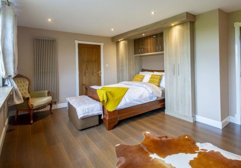 The main bedroom is all about style and comfort. There are built-in wardrobes, a vertical radiator and a window overlooking the front of the house.
