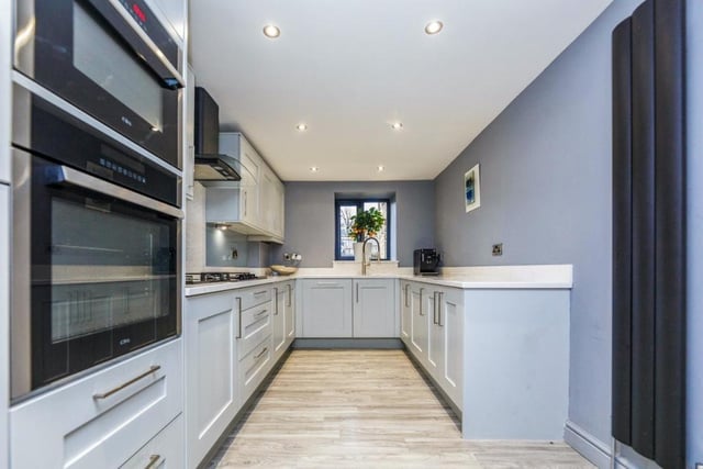 The bespoke fitted kitchen features integrated appliances and quartz work surfaces.