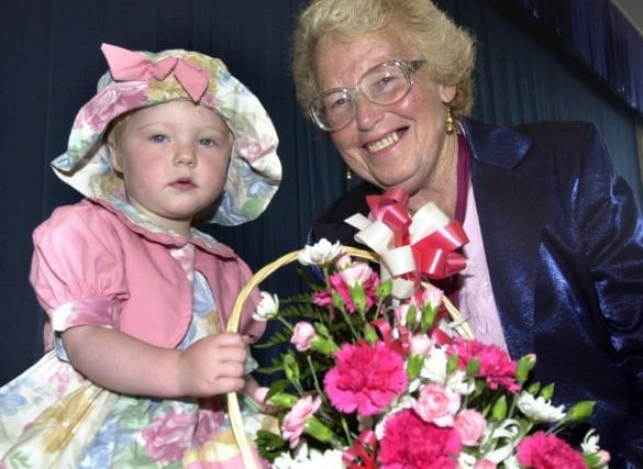 Two-year-old Mellisa Oliver hands over a basket of flowers to Berly Roberts at a Summer Fayre in 2000.