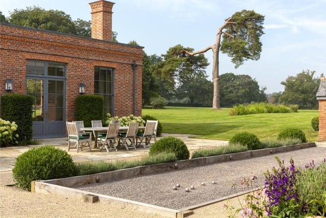 Luxurious extras are littered across the Baughurst House estate, including this petanque pitch. It is part of a French-style courtyard garden that sits outside an additional guest-cottage on the estate, known as the Coach House, and can be lit up at night as an entertaining space. Nearby is a hard tennis court.