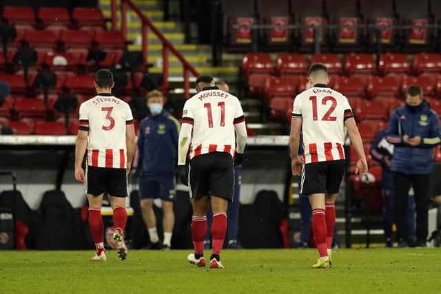 Enda Stevens, Lys Mousset and John Egan of Sheffield United walk off at the final whistle against Arsenal: Andrew Yates / Sportimage