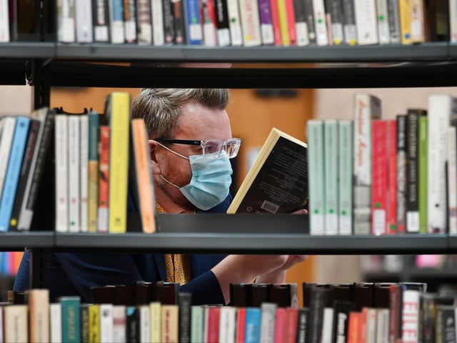 Chair of Glasgow Life,, Councillor David McDonald browsing some books at the Mitchell.