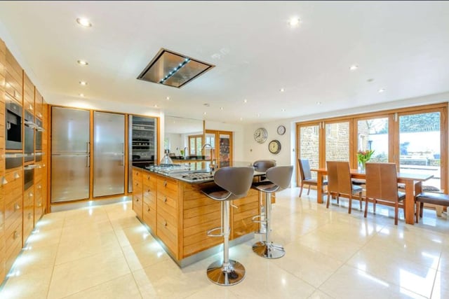 The kitchen and breakfast room boasts a modern design with extensive cabinets, sleek and simple hardware and a large L-shaped island unit which works as the stylish centrepiece of the room.