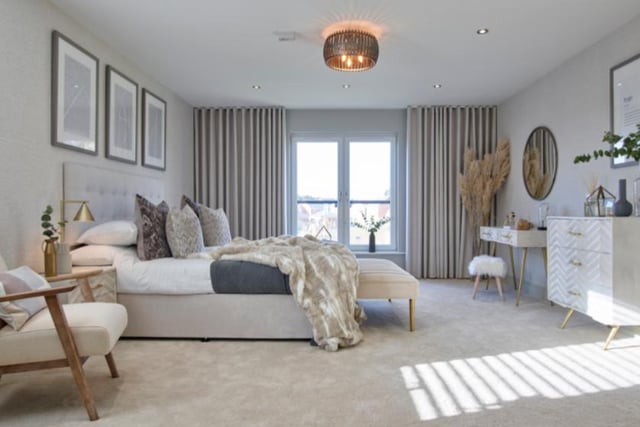 The master bedroom is nearly 19 feet wide and features double doors leading to a dressing room, as well as an en-suite with both a bath and shower and double sink units. 
Image by Robertson Homes.