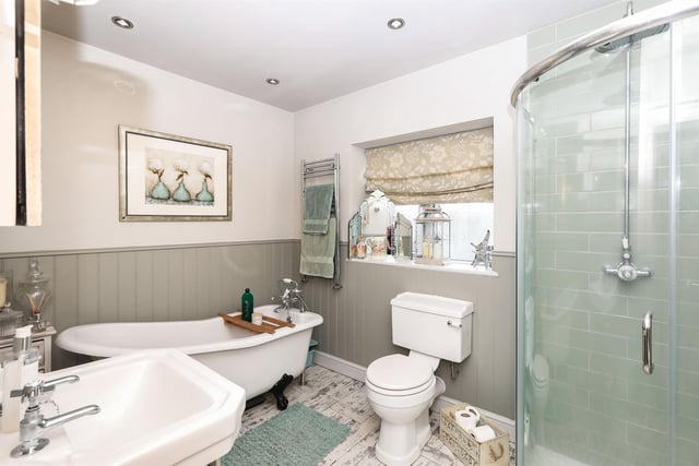 The family bathroom contains a freestanding bath, a walk-in shower with oversized circular rainfall shower head, a heated towel rail and spotlights in the ceiling.