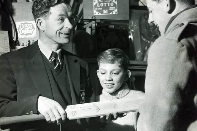 Former Sheffield United forward Jimmy Hagan (left) and his son, David, serving a customer in the sports shop he ran with former Sheffield United player Harold Brook on London Road, Sheffield, March 8, 1958