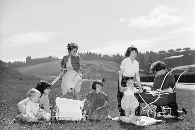 A group of girls playing 'mother' in Holyrood Park during their summer holidays in July 1959. The tenements of St Leonard's and Pleasance in the background on the right were soon to be demolished.