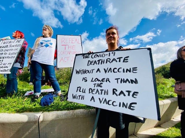 Protesters have been pictured carrying signs with messages on opposing safety restrictions brought in since government enforced lockdown and social distancing rules.