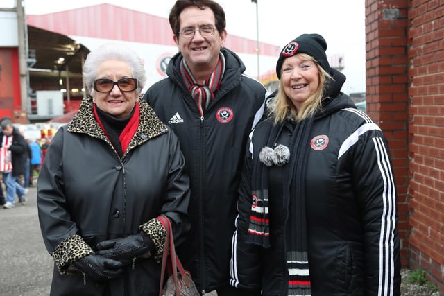 Three United supporters wrapped up warm before the Swindon Town home game in December 2016.