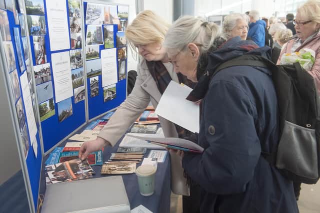 Visitors looking at a display at a past Sheffield Heritage Fair, held at the Millennium Gallery