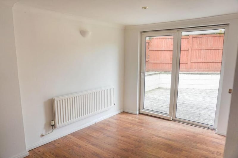 Airy spacious neutrally decorated room with wall mounted lights and ceiling spotlights, low maintenance flooring and patio doors opening onto the garden and patio decking providing a lovely social space to bring the outside in