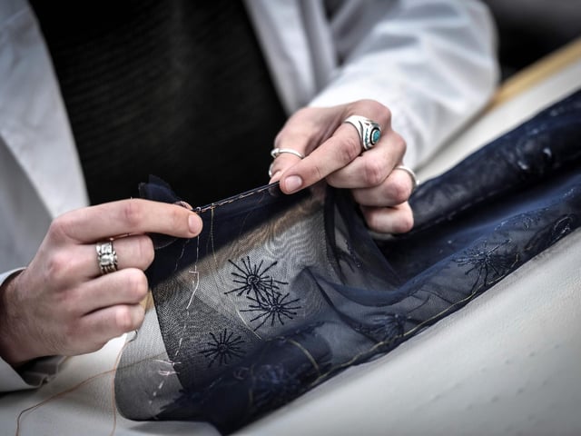 A seamstress works on a couture garment at Christian Dior's Haute Couture fashion house workshop