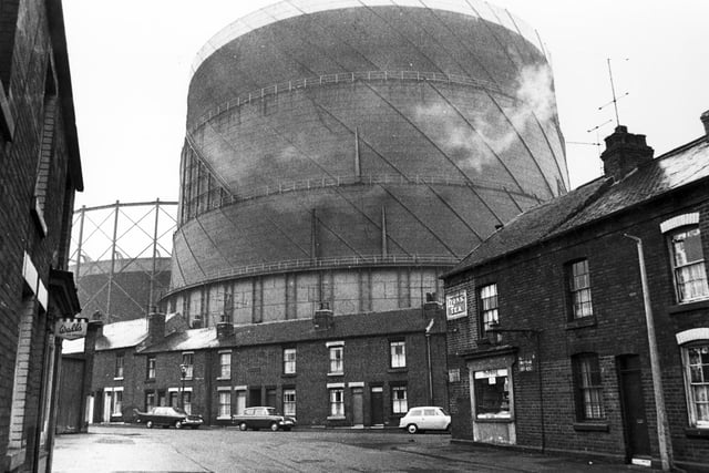 Houses and a corner shop living in the shadow of the Neepsend gasometers