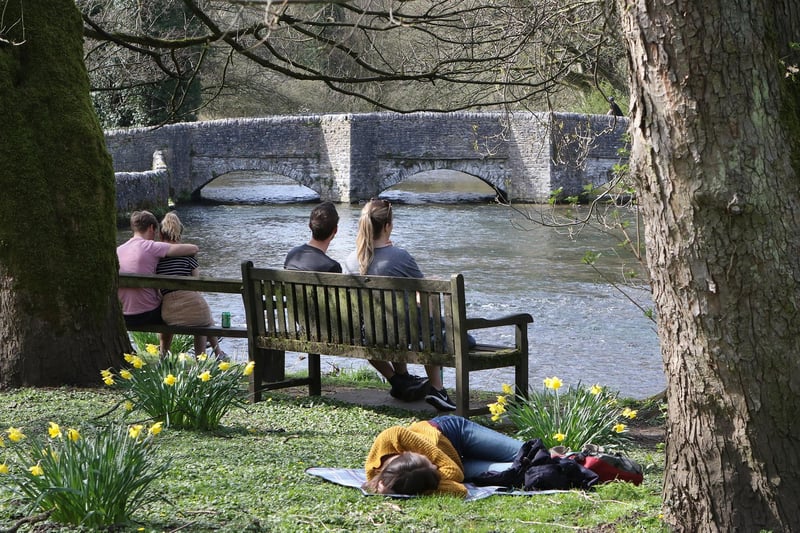 Sun bathing by the river in Ashford in the Water.
