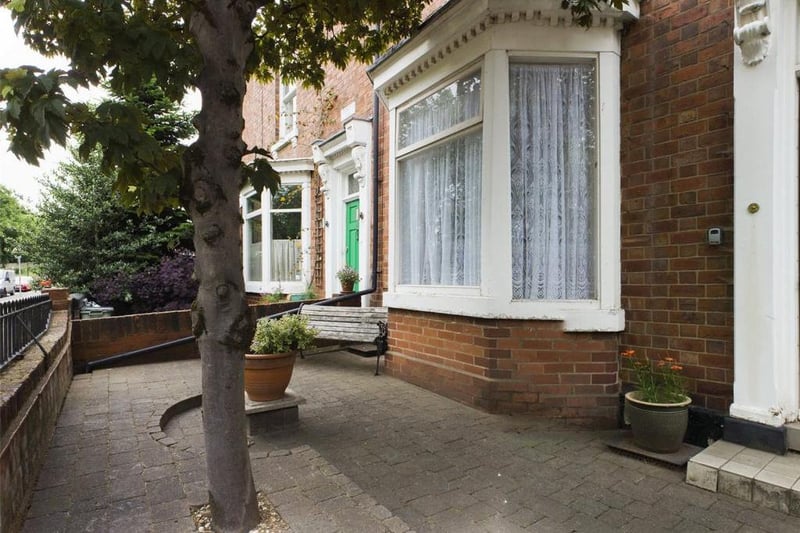 Front garden  - wall enclosed with wrought iron access gate and railings, block paved with mature tree.