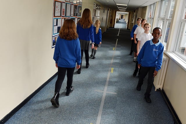 Children had to quickly adapt to new ways of doing things in order to keep schools running - children are pictured here at Charnock Hall Academy using a one-way system in a corridor.