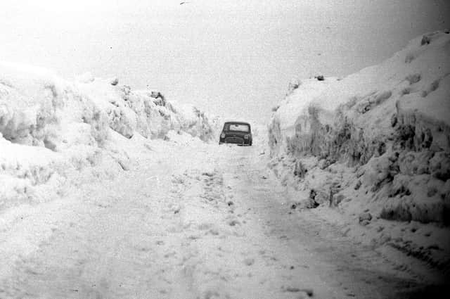 A giant drift on the Durham to Sunderland road at West Rainton. This car is dwarfed by the wall of snow in 1963.