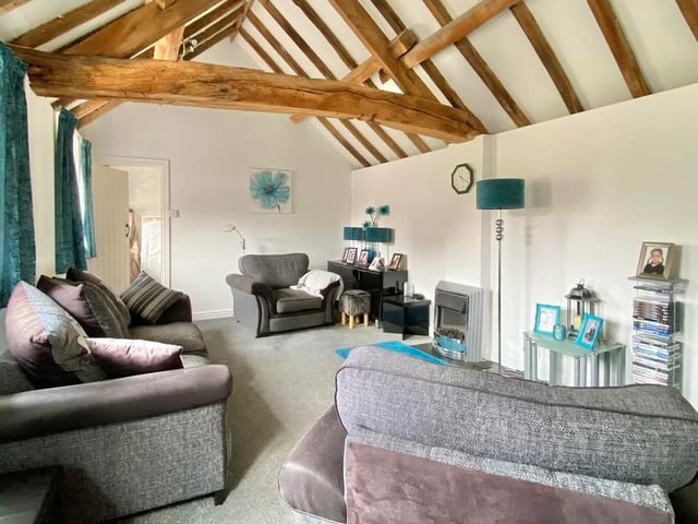 Here is the annexe lounge, with a vaulted ceiling and exposed beams. Windows overlook the courtyard of the property.