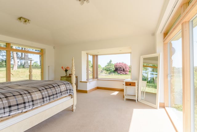The master bedroom boasts panoramic views, a large bay window and sliding doors that lead out to the garden.