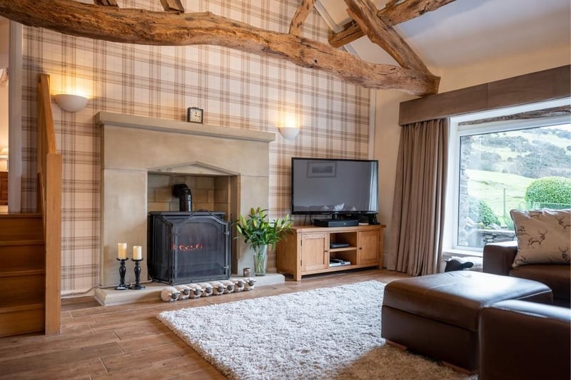 The living space features exposed beams, wooden floorboards and is kept toasty with a gas fired stove.