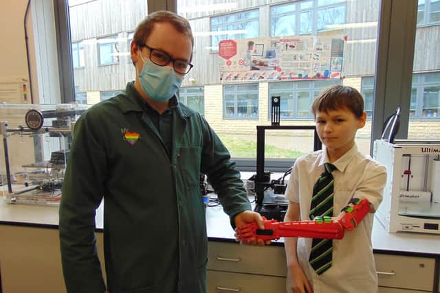 Teacher Dan Grant with Lewis and the 'bionic arm'.