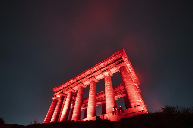 The red lighting extends into the air above Penshaw Monument.