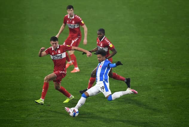 Josh Koroma of Huddersfield Town is closed down by Dael Fry and Anfernee Dijksteel of Middlesbrough.
