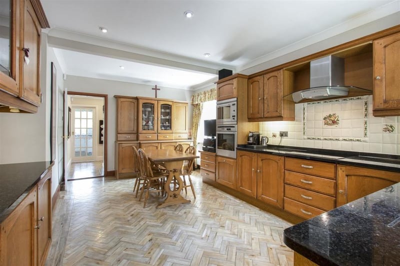 The cottage-style kitchen has integrated appliances and solid marble worktops and there's room for a family to eat there.