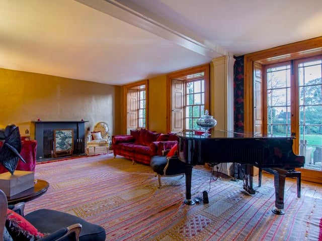 An elegant drawing room with sash windows and French doors.