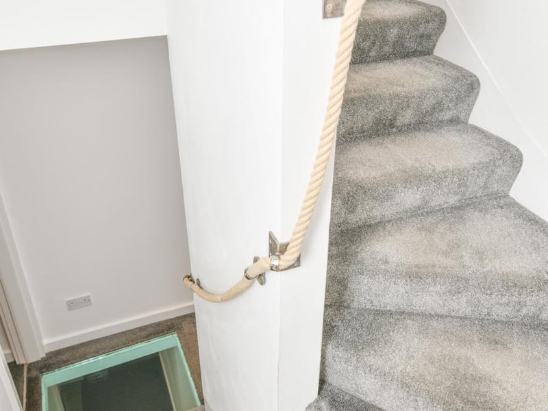 Staircase with glass panel on first floor landing.
