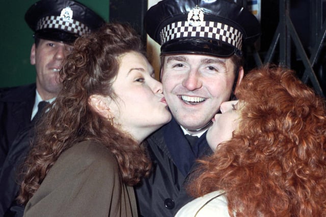 Two women kissing a police officer at the Tron kirk in Edinburgh on Hogmanay 1990.